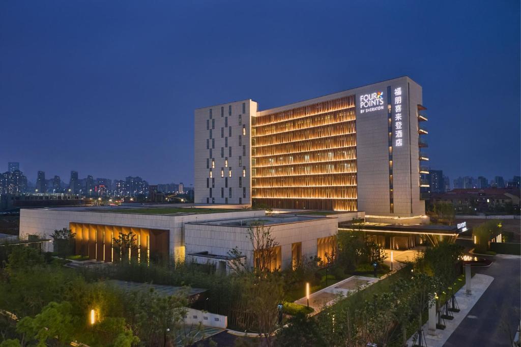 a hotel building with a lit up facade at night at Four Points by Sheraton Nanchang, Xihu in Nanchang