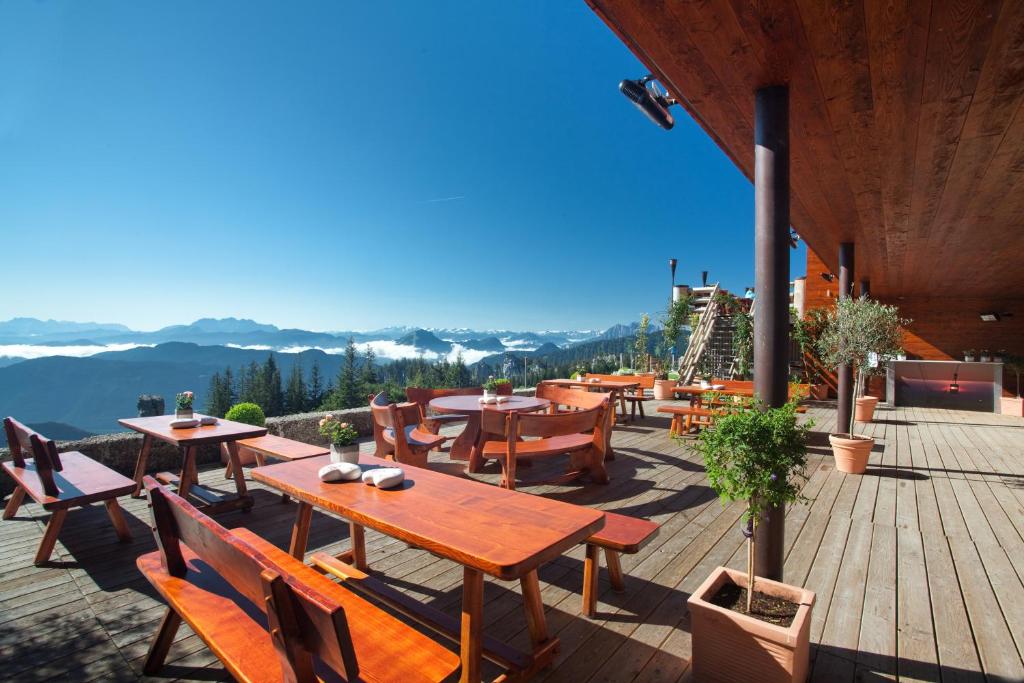 a patio with tables and chairs on a deck at Sonnenalm Kampenwand in Aschau im Chiemgau