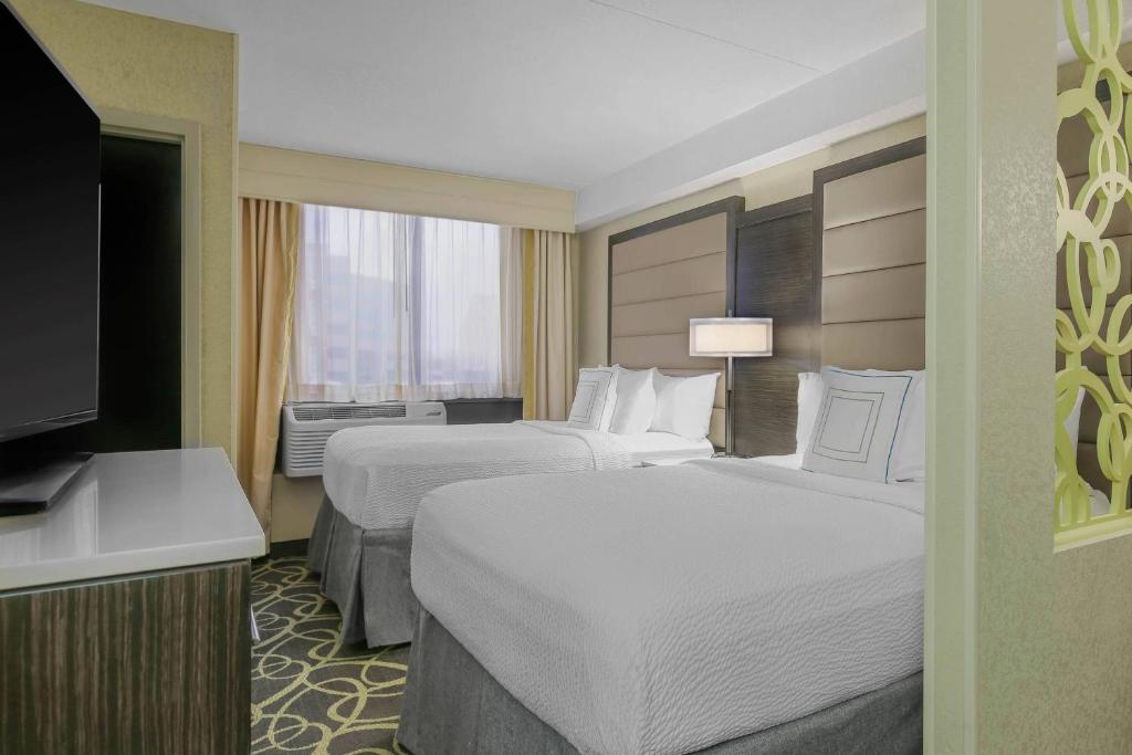 オクラホマシティにあるSpringHill Suites by Marriott Oklahoma City Quail Springsのベッド2台とテレビが備わるホテルルームです。