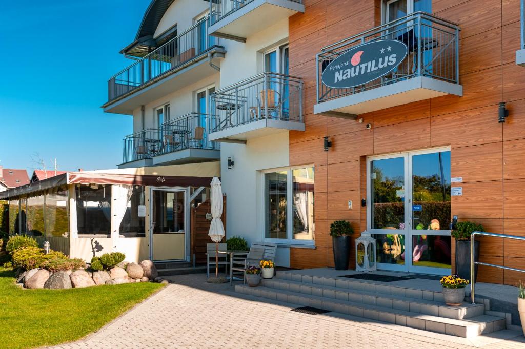 a building with a sign on the side of it at Pensjonat Nautilus in Karwia