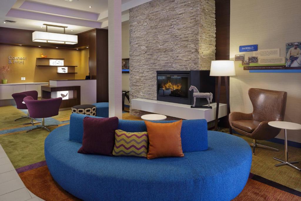 a living room with a blue couch and a fireplace at Fairfield Inn & Suites by Marriott Belleville in Belleville