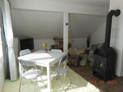 a white table and chairs in a room with a stove at Bei Hanna in Enying