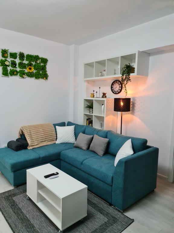 a living room with a blue couch and a table at Global Residence Lake View in Bucharest