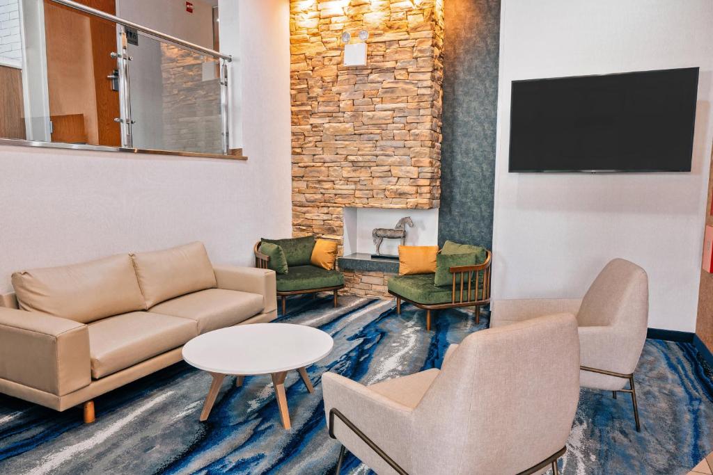 a waiting room with a couch and chairs and a fireplace at Fairfield Inn by Marriott New York LaGuardia Airport/Astoria in Queens