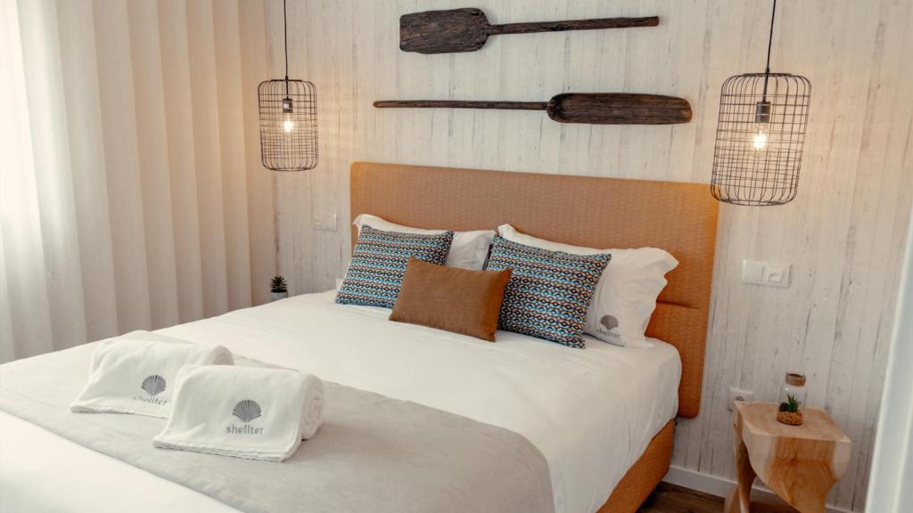 una camera con un letto con due cuscini sopra di Shellter Apartments by the sea a Vieira de Leiria