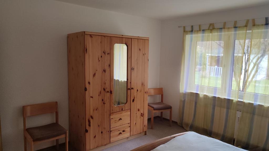 a bedroom with a wooden cabinet and a mirror at Leimbach in Bad Brückenau
