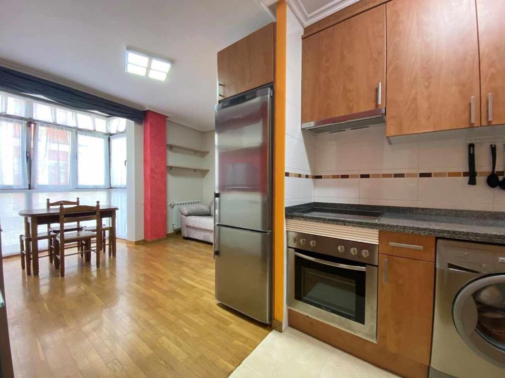 a kitchen with stainless steel appliances and a table at La Magdalena, piso en Villaviciosa VUT-3402-AS in Villaviciosa