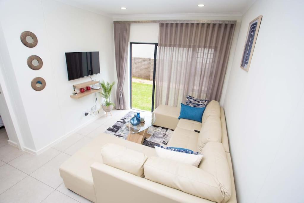 sala de estar con sofá blanco y TV en Secured and Fully equipped apartment- E en Lombardy East