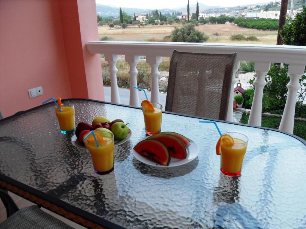 ナフプリオにあるOmorfi Poli 120 sqm Apartmentのフルーツプレートとオレンジジュース2杯付きテーブル