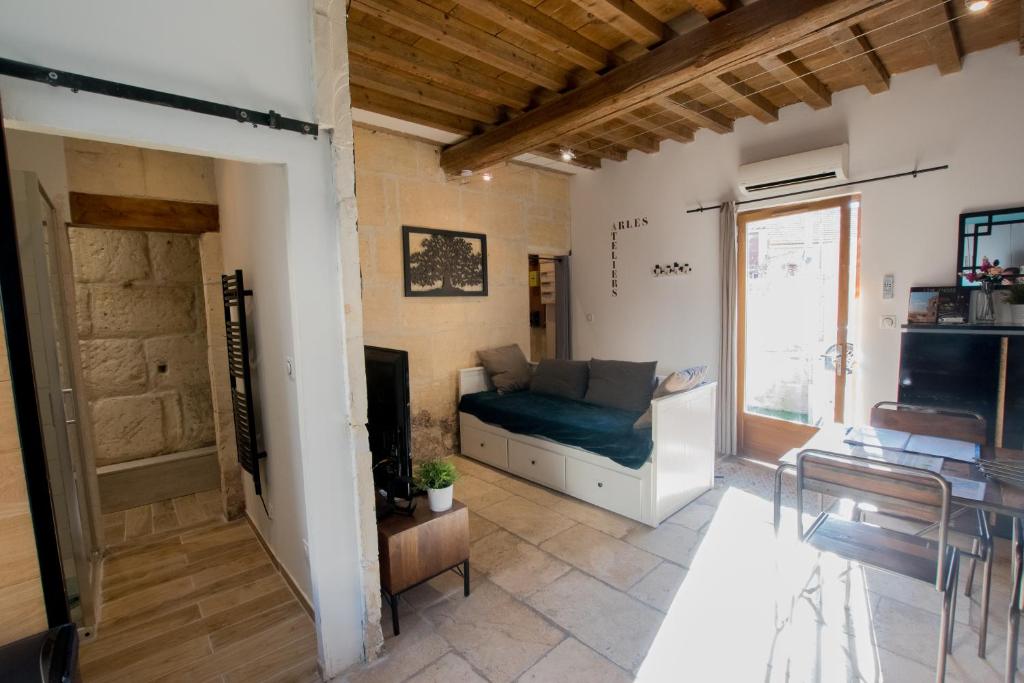 a living room with a couch and a window at Ateliers, Terrasse - Parking - Clim in Arles