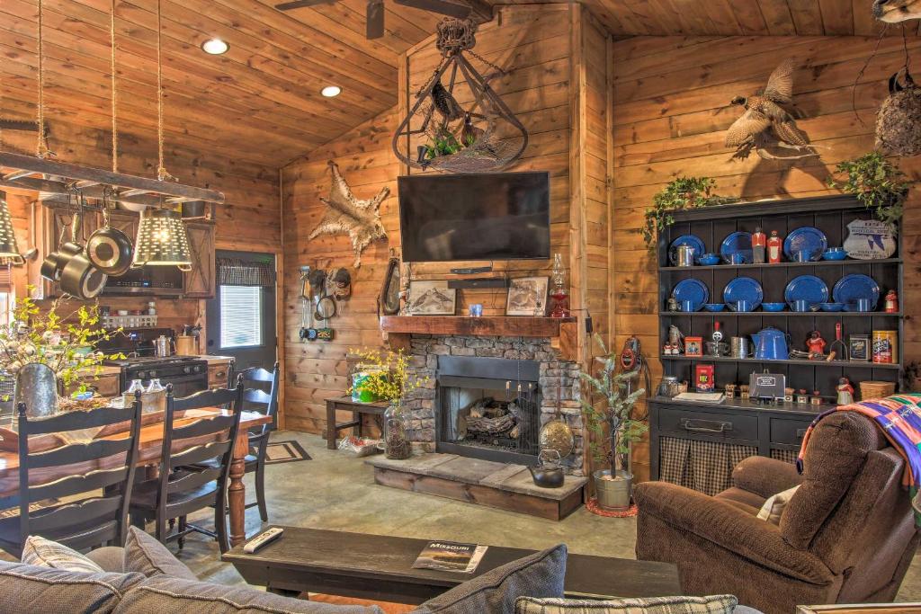 a living room with a fireplace in a log cabin at Missouri Vacation Rental with Fire Pit Access 