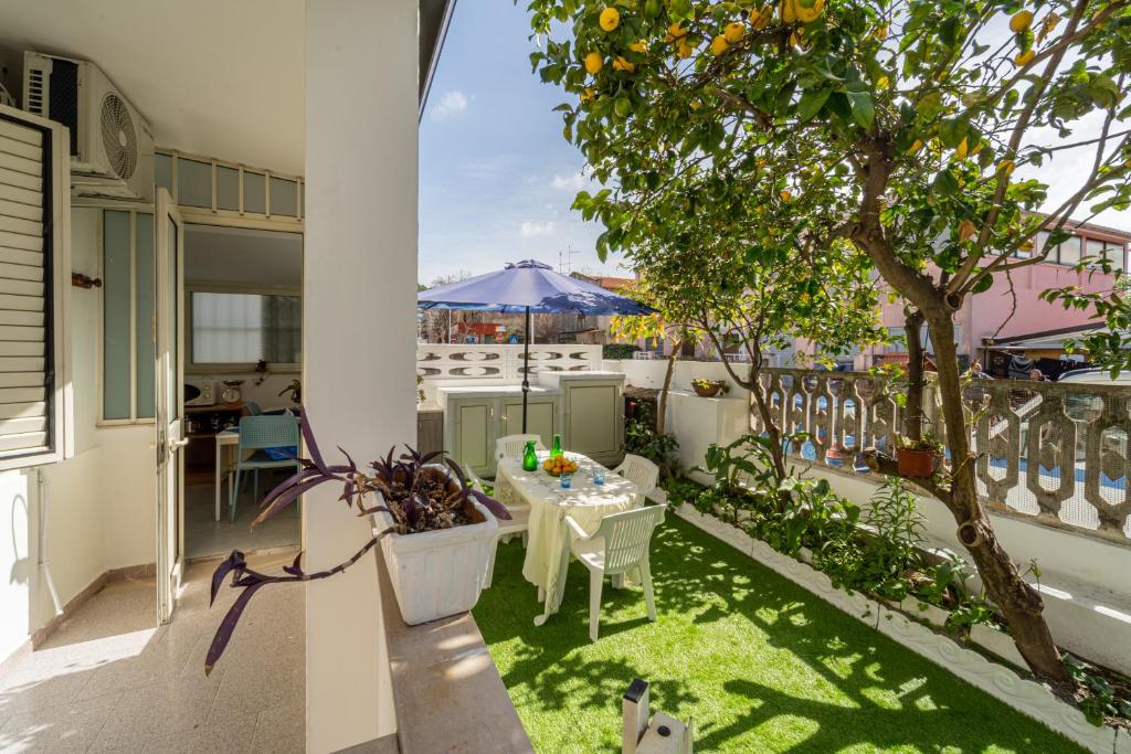 un patio con una mesa y un árbol en el balcón en Monolocale Gio en Carbonia