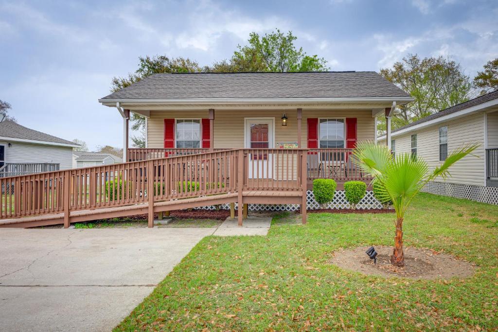 a home with a wooden deck and a house at Charming Biloxi Vacation Rental Near Beach! in Biloxi