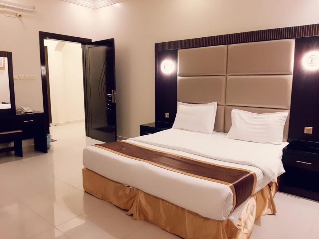 a bedroom with a large bed and a mirror at Ritan Apart-Hotel in Taif