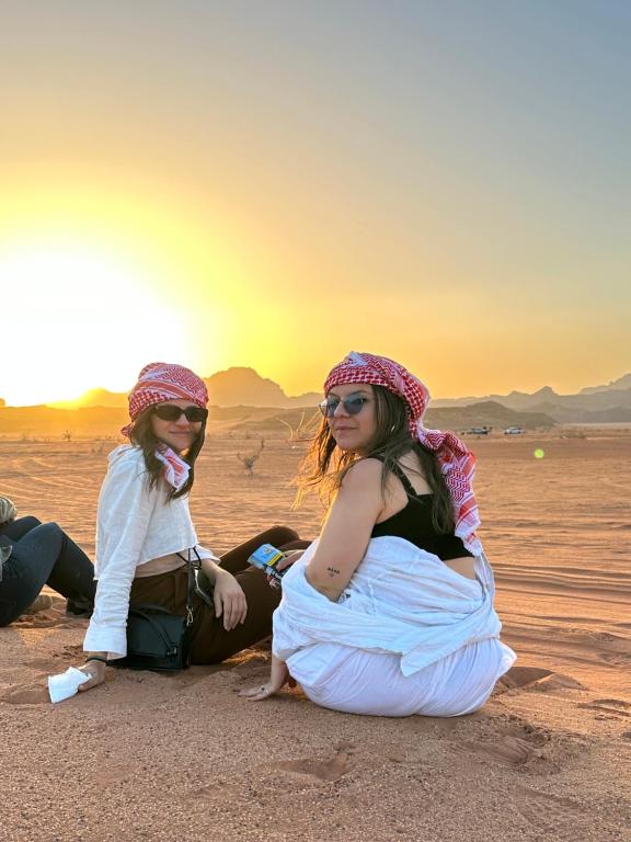 two girls sitting in the desert at sunset at Panorama Luxury Camp in Wadi Rum