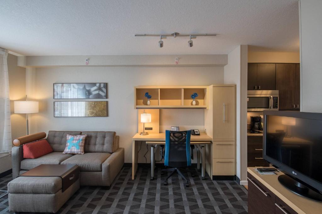 a living room with a couch and a table in a room at TownePlace Suites by Marriott Provo Orem in Orem