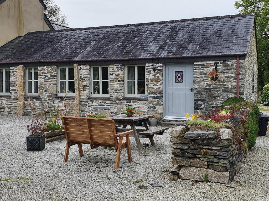 a stone cottage with a bench in front of it at Mimi's Cottage in Liskeard