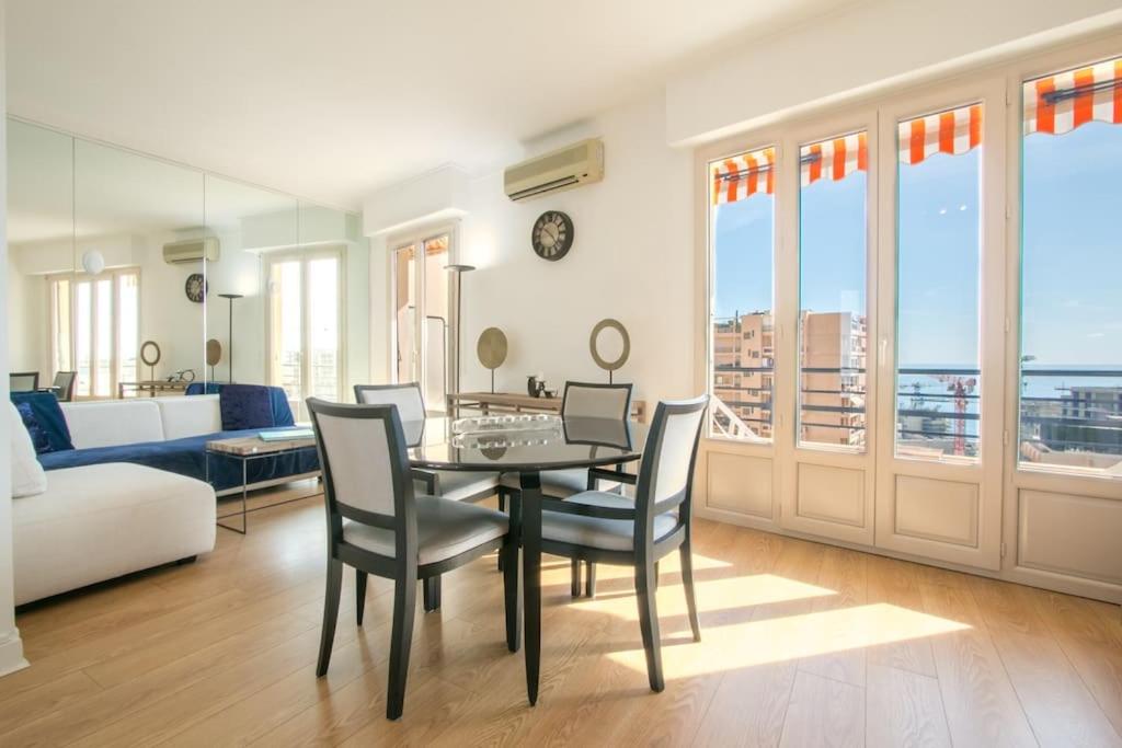 a living room with a table and chairs and a couch at Spacieux 3 Pièces de standing au centre de Monaco in Monte Carlo