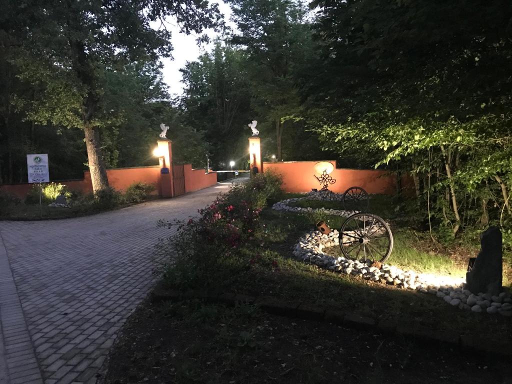 uma passarela de tijolos com luzes num parque à noite em Relais Cà del rio em Botteghino di Zocca
