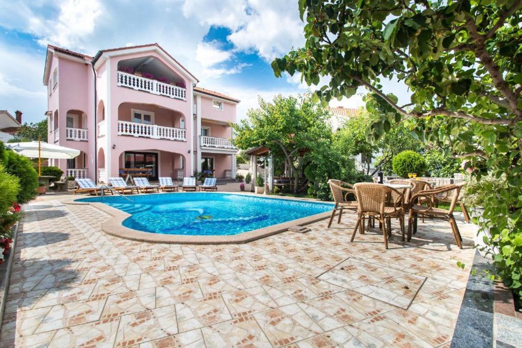 a villa with a swimming pool and a house at Apartman Naomi in Krk