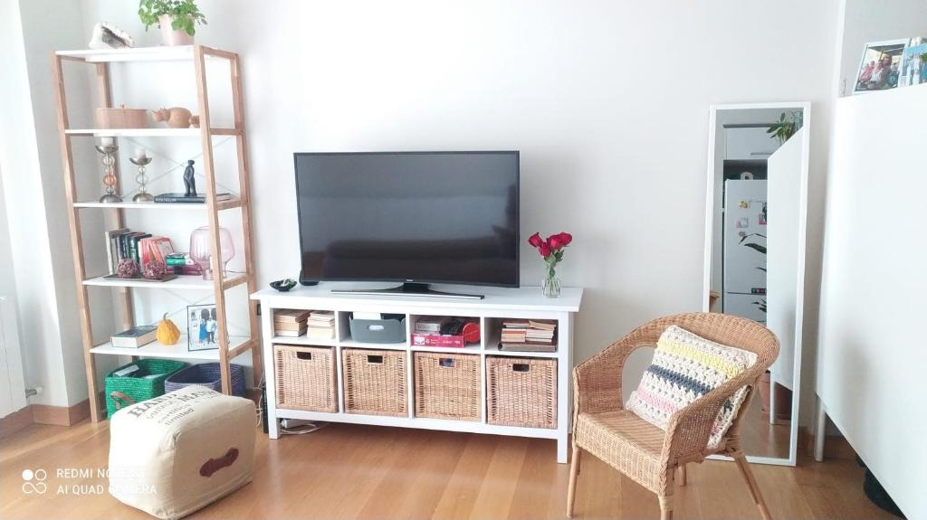 a living room with a television on a white entertainment center at Studio DORIA in Sant Boi del Llobregat