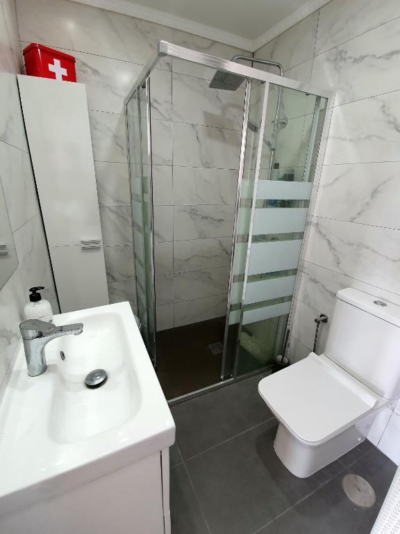 łazienka z toaletą, umywalką i prysznicem w obiekcie Apartamentos Los Cóndores w mieście Torremolinos