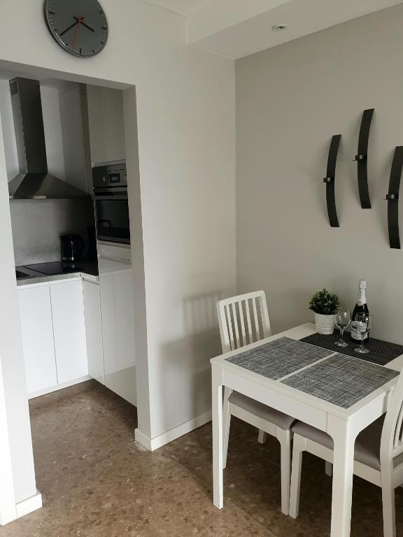 stół i krzesła w kuchni z zegarem na ścianie w obiekcie Apartamentos Los Cóndores w mieście Torremolinos