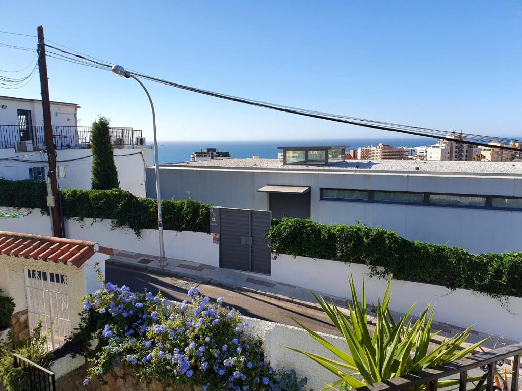 widok na budynek z kwiatami i ocean w obiekcie Apartamentos Los Cóndores w mieście Torremolinos