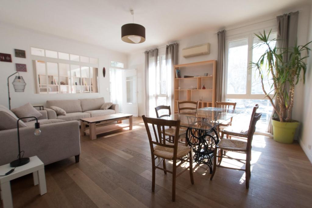 ein Wohnzimmer mit einem Tisch, Stühlen und einem Sofa in der Unterkunft Marcat - Clim - Patio in Arles