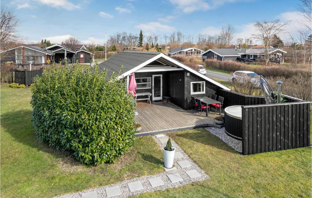 une petite maison noire avec une terrasse en bois dans l'établissement Stunning Home In Juelsminde With Kitchen, à Sønderby