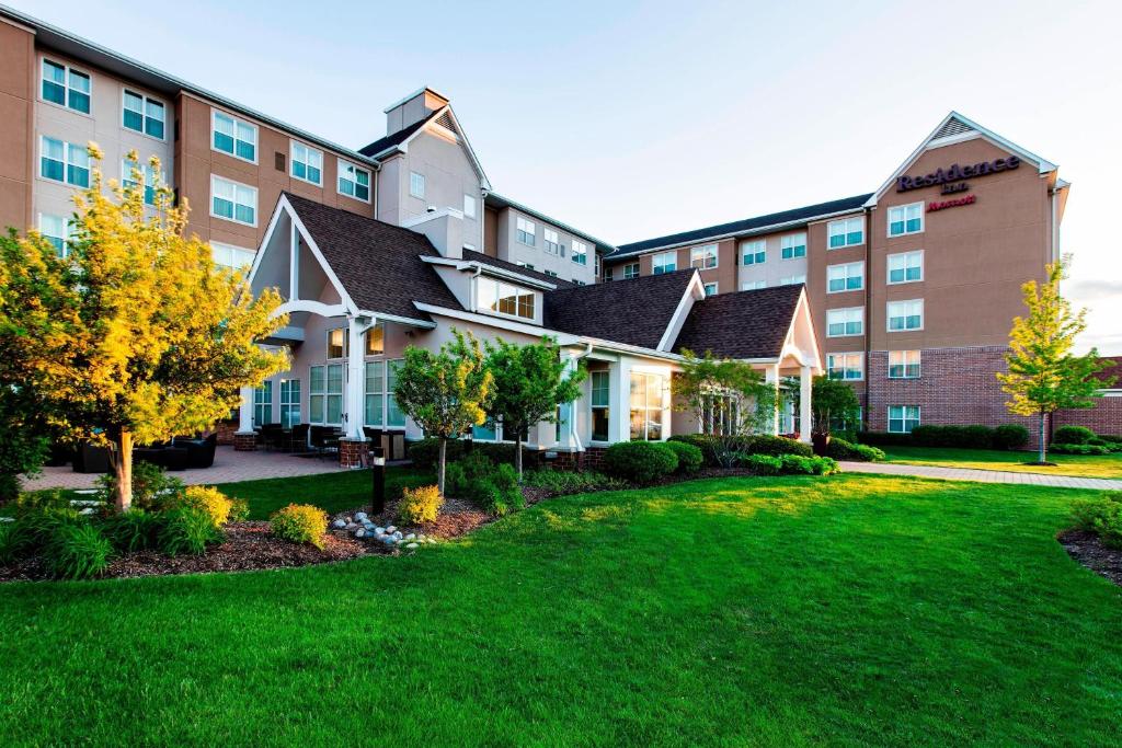 un grand bâtiment avec une pelouse devant lui dans l'établissement Residence Inn Chicago Midway Airport, à Bedford Park