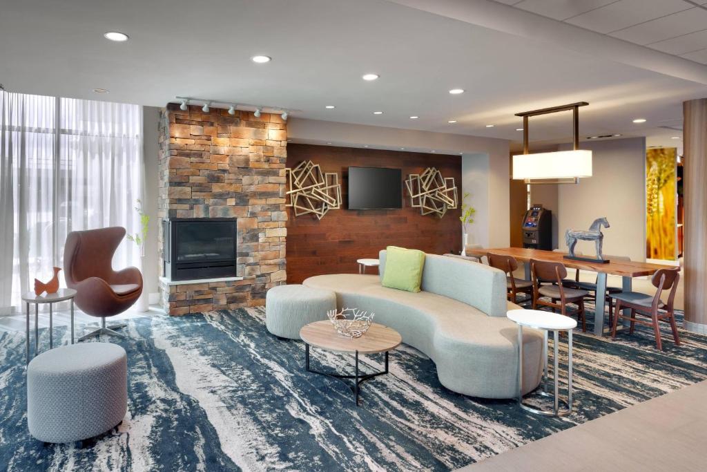 Fairfield Inn & Suites by Marriott Springfield North في سبرينغفيلد: غرفة معيشة مع أريكة وطاولة