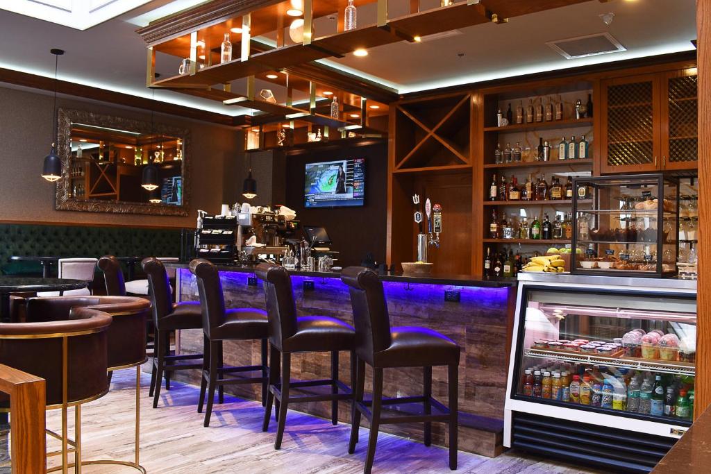 um bar com bancos pretos num restaurante em Delta Hotels by Marriott Indianapolis East em Indianápolis