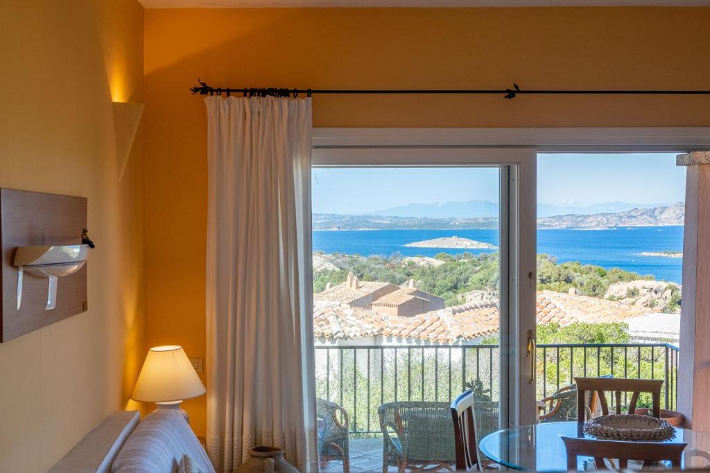 a room with a large window with a view of the ocean at Appartamento Vista Mare 3 Min Porto Cervo in Liscia di Vacca
