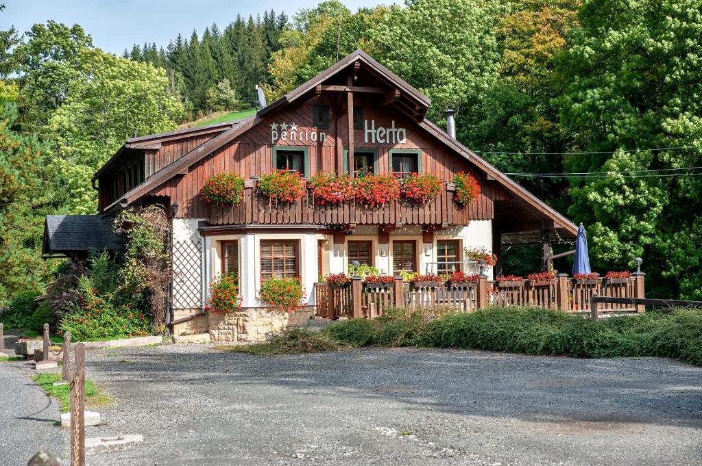 een huis met bloembakken aan de voorkant bij Pension Herta in Horní Maršov