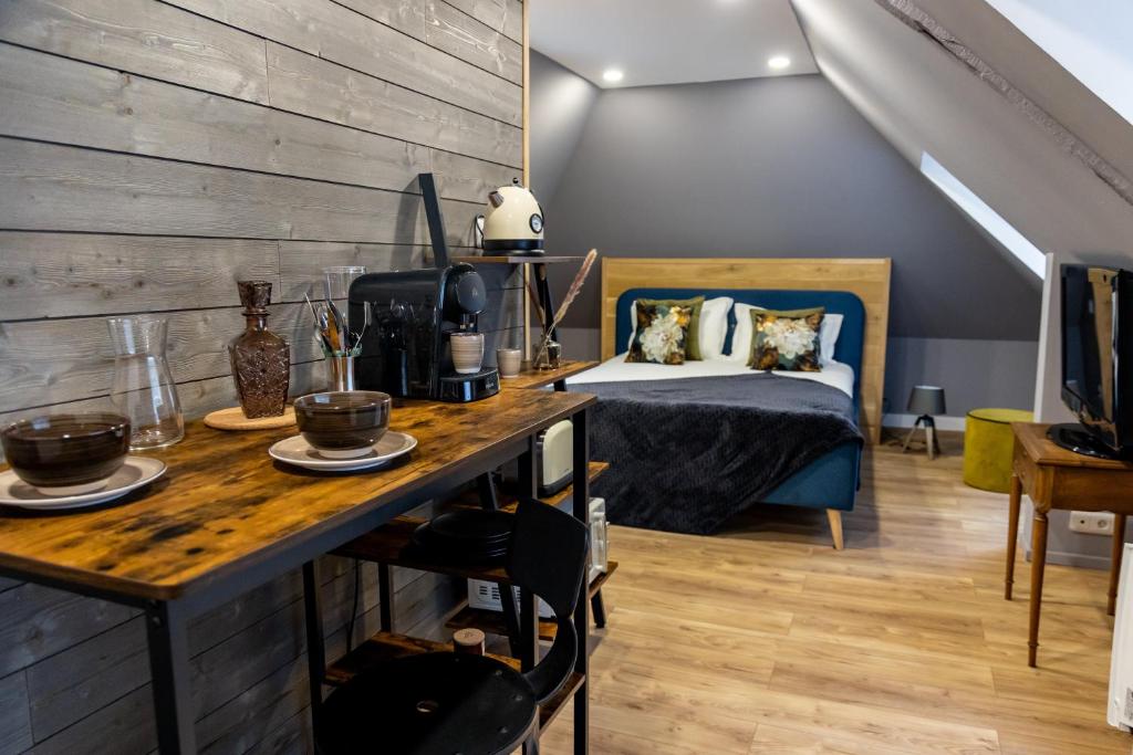 a room with a bed and a wooden table with plates on it at Escapade Place 11 N5B - Studio Dinan centre in Dinan