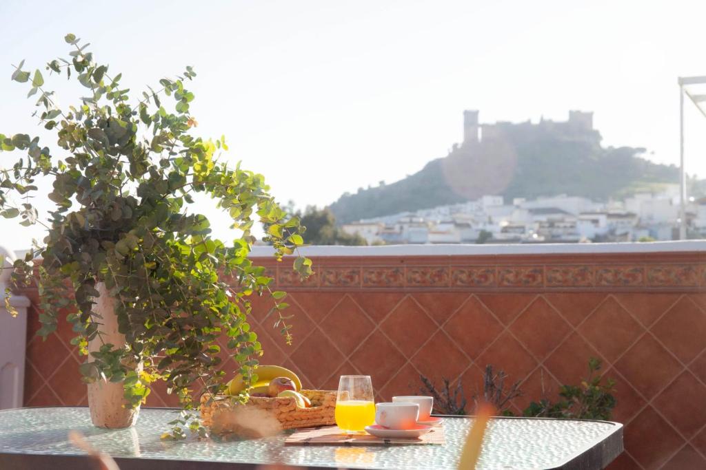 een tafel met 2 glazen sinaasappelsap op een balkon bij Casa Rural La Palmera in Almodóvar del Río