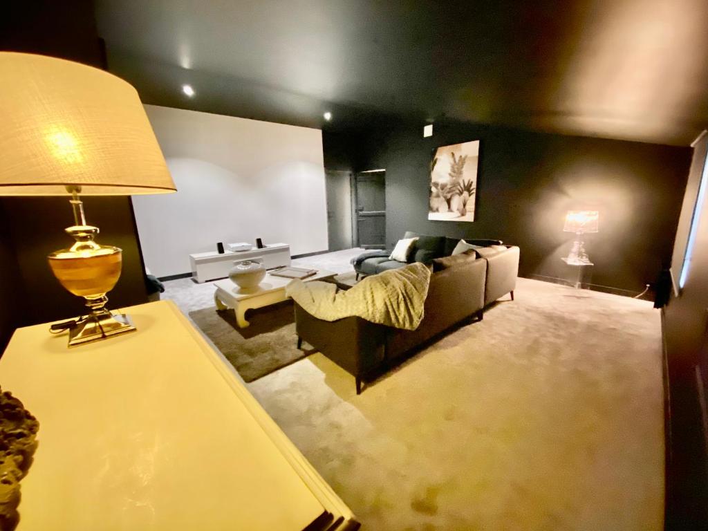 sala de estar con sofá y mesa con lámpara en Suite Vieille Rose, en Niort
