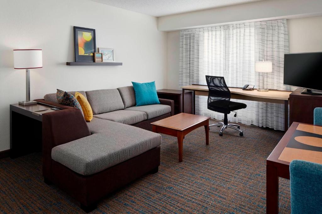 a living room with a couch and a desk at Residence Inn Saint Louis Airport / Earth City in Earth City