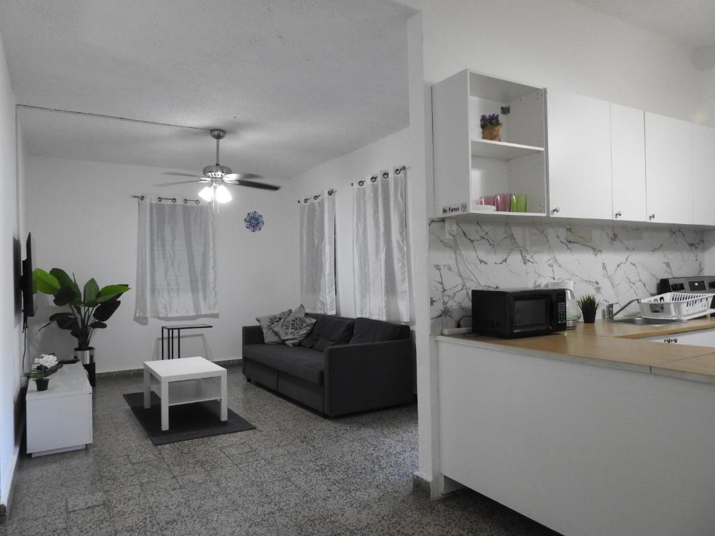 a kitchen and a living room with a couch at Casa Del Sol-Unit A in Bayamón