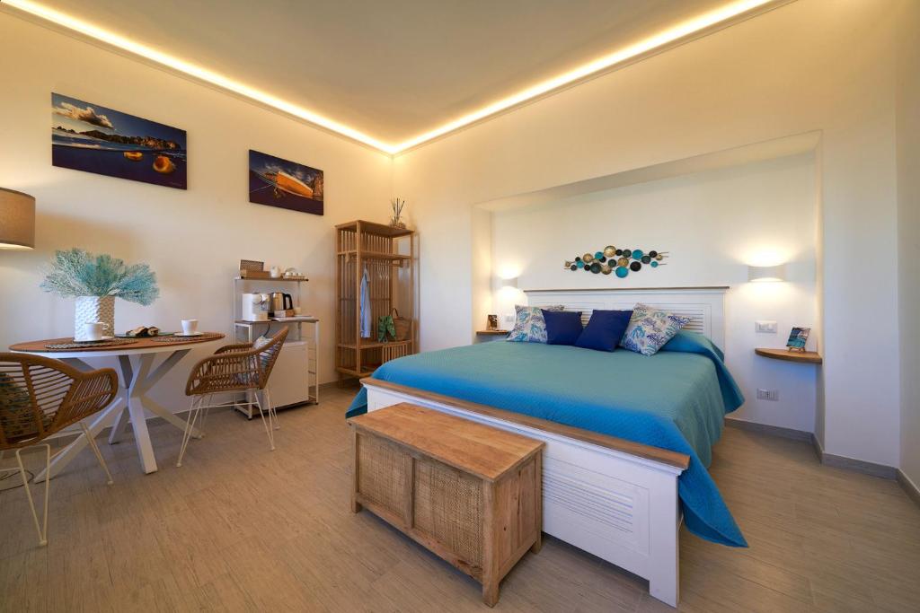 um quarto com uma cama azul e uma mesa em That's Amore Capri em Anacapri