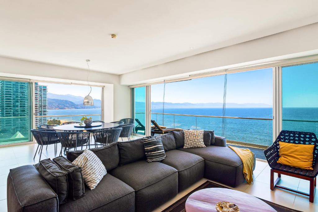 a living room with a couch and a view of the ocean at Seize The Sun, 1-1505 in Puerto Vallarta