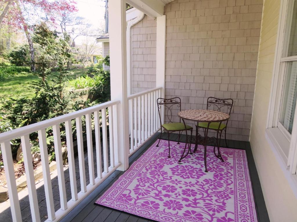 - une terrasse couverte avec 2 chaises et une table sur un tapis dans l'établissement 21 Beechwood Road Centerville Cape Cod - Mermaid's Rest, à Centerville