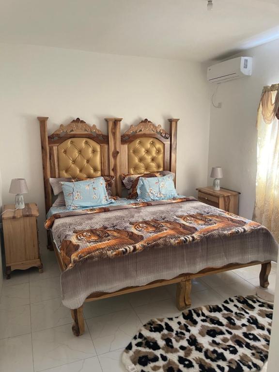 a bedroom with a large bed with blue pillows at Mount Royal Estate Cozy Comfort in Portmore