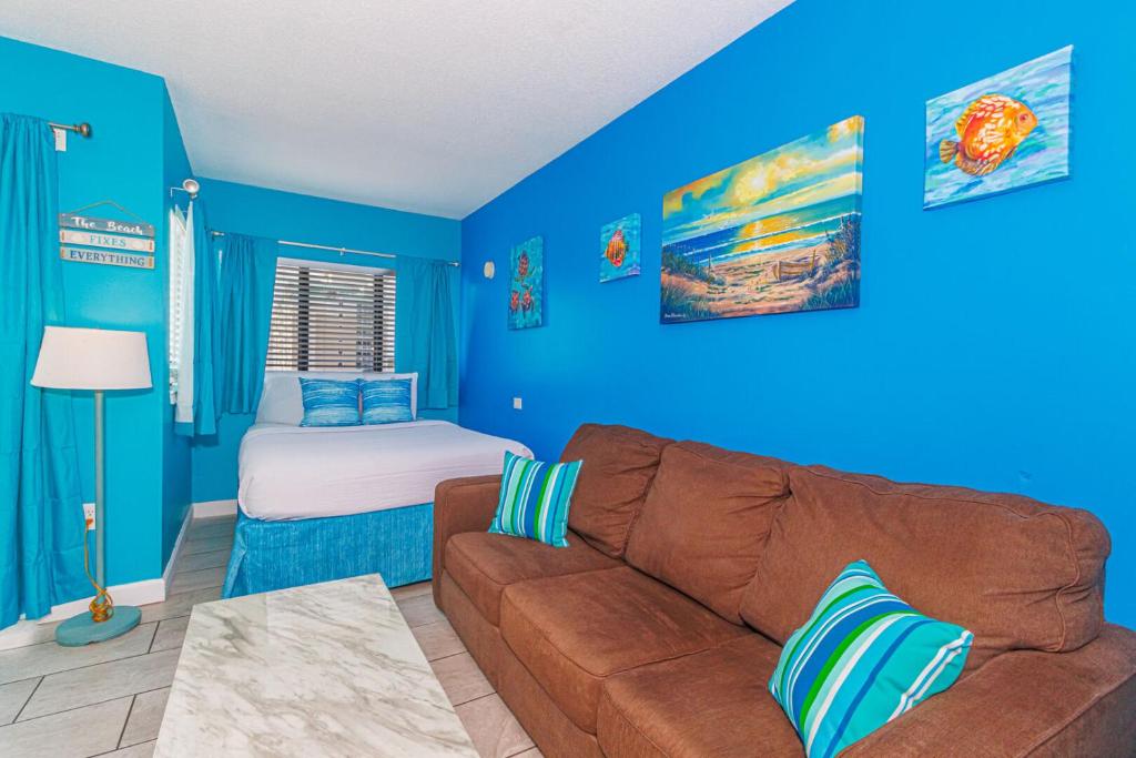 ein blaues Wohnzimmer mit einem Sofa und einem Bett in der Unterkunft The Palace 705 in Myrtle Beach