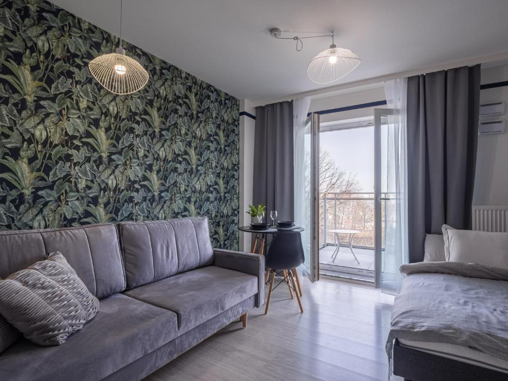 a living room with a couch and a wall mural at Enes Apartments Softy Lofty 4 in Wrocław