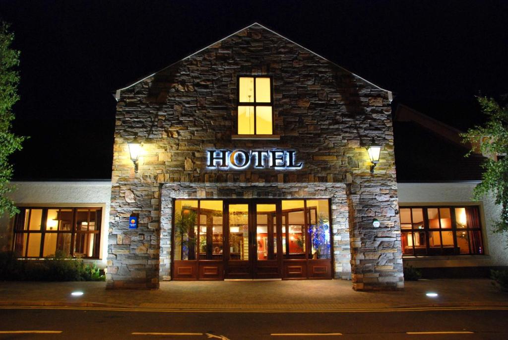 een hotelgebouw 's nachts met een bord dat hotel leest bij Dunsilly Hotel in Antrim