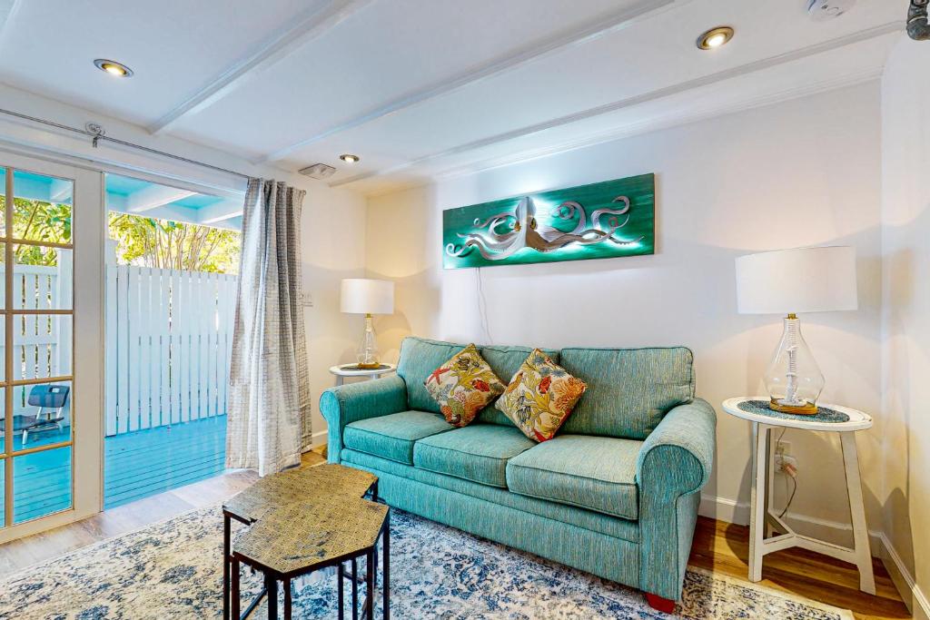 een woonkamer met een blauwe bank en een raam bij The Coral Cove in Key West