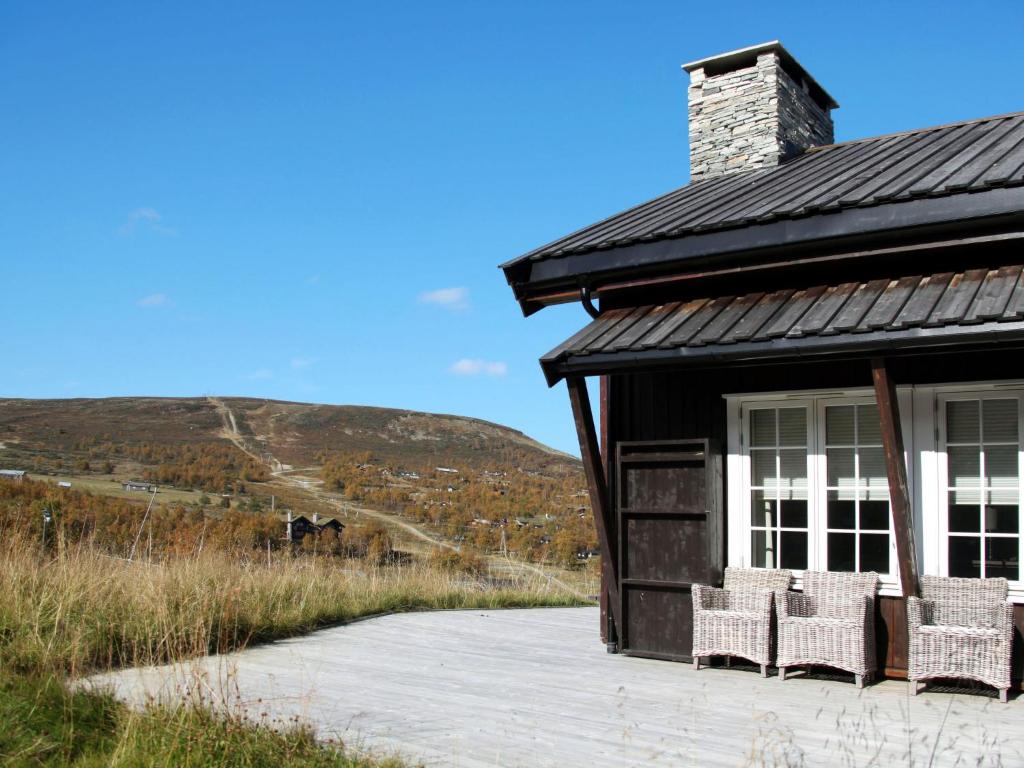 a house with wicker chairs sitting on a porch at Apartment Havsdalshovda - HLD101 by Interhome in Geilo
