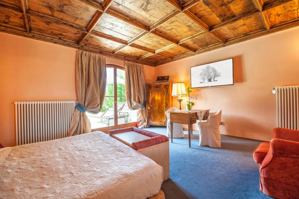 um quarto de hotel com uma cama e uma secretária em Villa Orso Grigio em Ronzone
